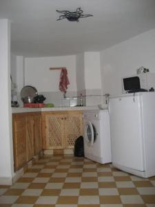 a kitchen with a white refrigerator and a washing machine at Appartement dans la médina in Asilah