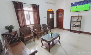 a living room with chairs and a table and a tv at Casa Diversa in Esquipulas