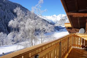 a winter view from a cabin balcony with snow covered trees at Seeberhof in Racines