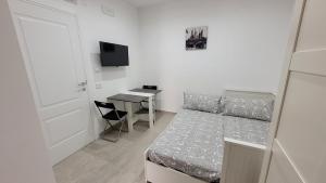 a small bedroom with a bed and a desk at Maison Ginevra in Pompei