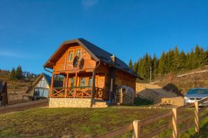 une maison en bois avec un toit noir sur une colline dans l'établissement Tarovuk cabin, à Zaovine