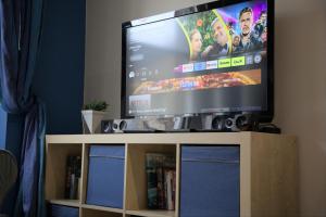 a flat screen tv sitting on top of a tv stand at Cosy n Comfy Flat in Historic Heart of Edinburgh in Edinburgh