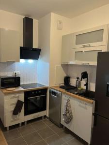 a kitchen with a sink and a stove top oven at Chez David in Villejuif