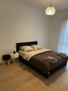 een slaapkamer met een bed, een tafel en een lamp bij Chez David in Villejuif