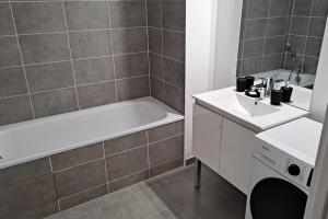een badkamer met een bad, een wastafel en een bad bij Chez David in Villejuif