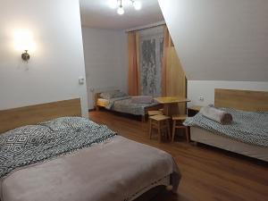 a hotel room with two beds and a table and a tableablish at PRZY POTOKU -noclegi in Białka Tatrzańska