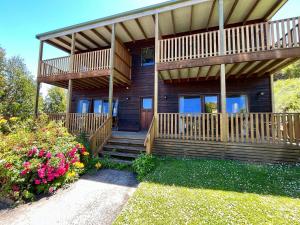Cabaña de madera con terraza y porche en Daysy Hill Country Cottages, en Port Campbell