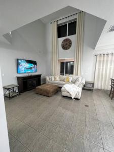 ein Wohnzimmer mit 2 Sofas und einem Flachbild-TV in der Unterkunft Emerald Island Private Pool Home near Disney in Kissimmee