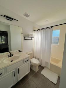 ein weißes Bad mit einem Waschbecken und einem WC in der Unterkunft Emerald Island Private Pool Home near Disney in Kissimmee