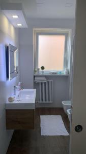baño con lavabo y aseo y ventana en Agasweethome Rome Gemelli, en Roma