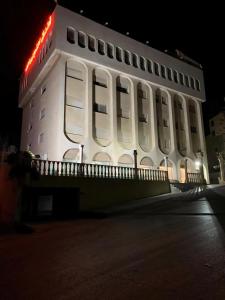 a white building with a red sign on it at Nojoom Hotel in Amman