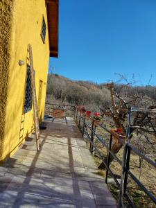 a yellow building with a walkway next to a fence at Chalet Etna in Biancavilla