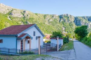 a house with a fence in front of a mountain at Holiday Home Harmony in Mostar