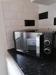 a microwave sitting on a counter in a kitchen at Chantilly in Ickenham