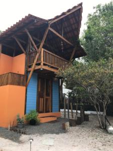 Dieses Haus in Blau- und Orangetönen verfügt über einen Balkon. in der Unterkunft Chale Tupinambá Imbassai in Imbassai