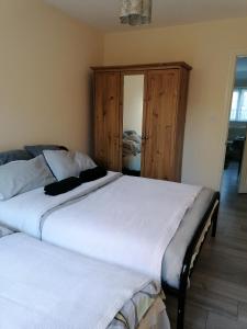 2 camas individuales en un dormitorio con sofá cama en Chantilly en Ickenham