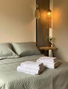 Una cama con dos toallas encima. en Complejo Los Olivos en Cafayate