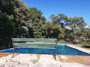 un banco verde junto a una piscina en Corralito Extremo en Rosario de Lerma