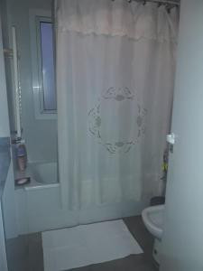 y baño con cortina de ducha y aseo. en Balcón del Cielo en Salta