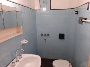 Baño de azulejos azules con aseo y lavamanos en Hospedaje Legus en San Carlos de Bariloche