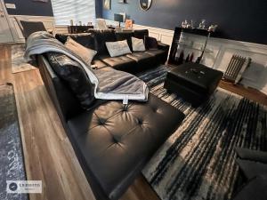 a living room with a black leather couch and a rug at 4 - Bed home with Cali King Bed, 12 mins to DTWN in Atlanta