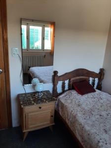 - une chambre avec 2 lits et une table avec un miroir dans l'établissement Hospedaje Legus, à San Carlos de Bariloche