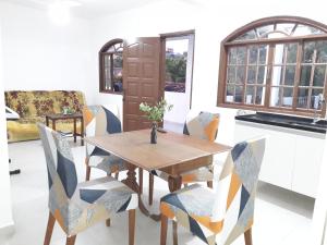 comedor con mesa de madera y sillas en Recanto da Colina, en Cabo Frío