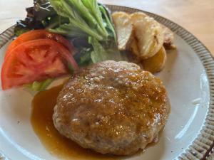 a white plate with a burger and vegetables on it at irodori in Matsumoto