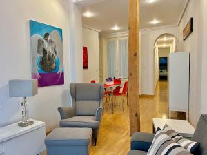 sala de estar con sofá, sillas y mesa en Alojamiento entero centro: piso . CHUECA, en Madrid