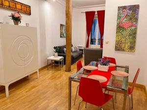 sala de estar con mesa y sillas rojas en Alojamiento entero centro: piso . CHUECA, en Madrid