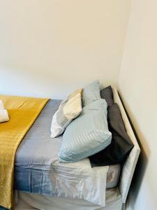a bed with pillows on it in a room at Beautiful Private Rooms in London Central Willesden Green in London