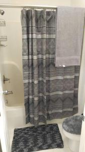 a bathroom with a shower curtain and a toilet at Two bedroom Sea Trail condo in Sunset Beach in Sunset Beach