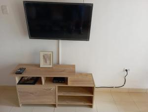 a flat screen tv sitting on top of a wooden entertainment center at Apartamento Hogar Caribeño 2H con AA in Santa Marta