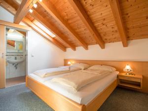 Cette chambre dispose d'un grand lit et de plafonds en bois. dans l'établissement Haus Irmgard 1, à Mathon
