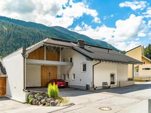 a white building with a garage with a red car in it at Haus Irmgard 1 in Mathon