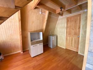 an empty room with a refrigerator and a door at Araucaria Lodge in Curacautín