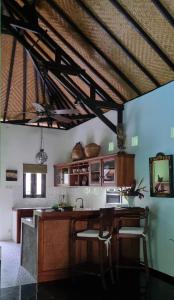 Una cocina con gabinetes de madera y techo de madera. en Villa Jati - Private Poolside Villa Central Lovina, en Lovina
