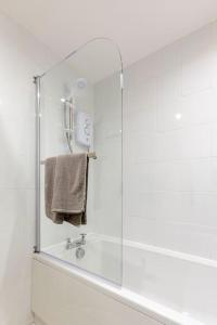 a bathroom with a shower with a glass door at Spacious stylish centraly located flat near beach in Largs