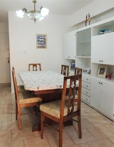 una cocina con mesa y sillas y una cocina con armarios blancos. en Welcome MDP Solo familias en Mar del Plata