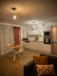 een woonkamer met een bank en een tafel en een keuken bij Nature&Spa Appartement avec Jacuzzi & Sauna privé in Orléans