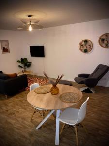sala de estar con mesa y sillas en Nature&Spa Appartement avec Jacuzzi & Sauna privé, en Orléans