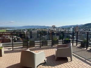balcón con 2 sillas y vistas a la ciudad en Torre Leonardo I en Villa Carlos Paz