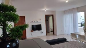 a living room with a tv and a table with chairs at Pentadaktylos Mountain view apt 2 bedroom in Nicosia