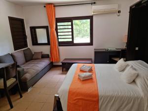 a living room with a bed and a couch at Hotel Oasis de Kiamu in Lifou