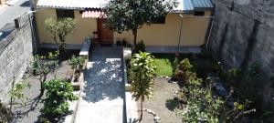 a garden with trees and plants in front of a house at Departamento en el centro de la ciudad de Baños con netflix, wifi, garage gratuito y una excelente vista in Baños