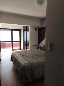 a bedroom with a bed and a large window at Depto 2 amb- Punta Mogotes- ideal para altos in Mar del Plata