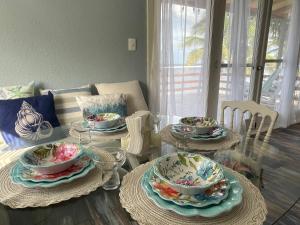 una mesa de comedor con platos y platos. en Gorgeous Oceanfront Villa Solana with Pool and Direct Beach Access, en Santa Clara