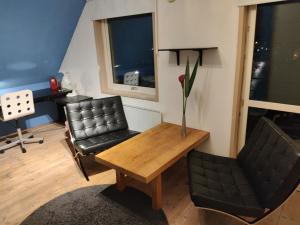 a living room with a table and a chair and a desk at Pink House Room#2 Stockholm in Stockholm