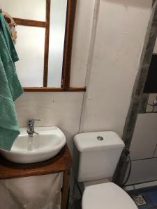 y baño con aseo blanco y lavamanos. en Cabaña Iris, en La Paloma