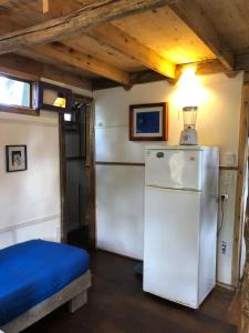 een kleine kamer met een koelkast en een bed bij Cabaña Iris in La Paloma +15 foto's